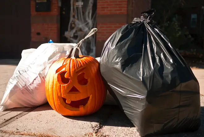 This is a photo of a Jack-o-Lantern and two trash bags.